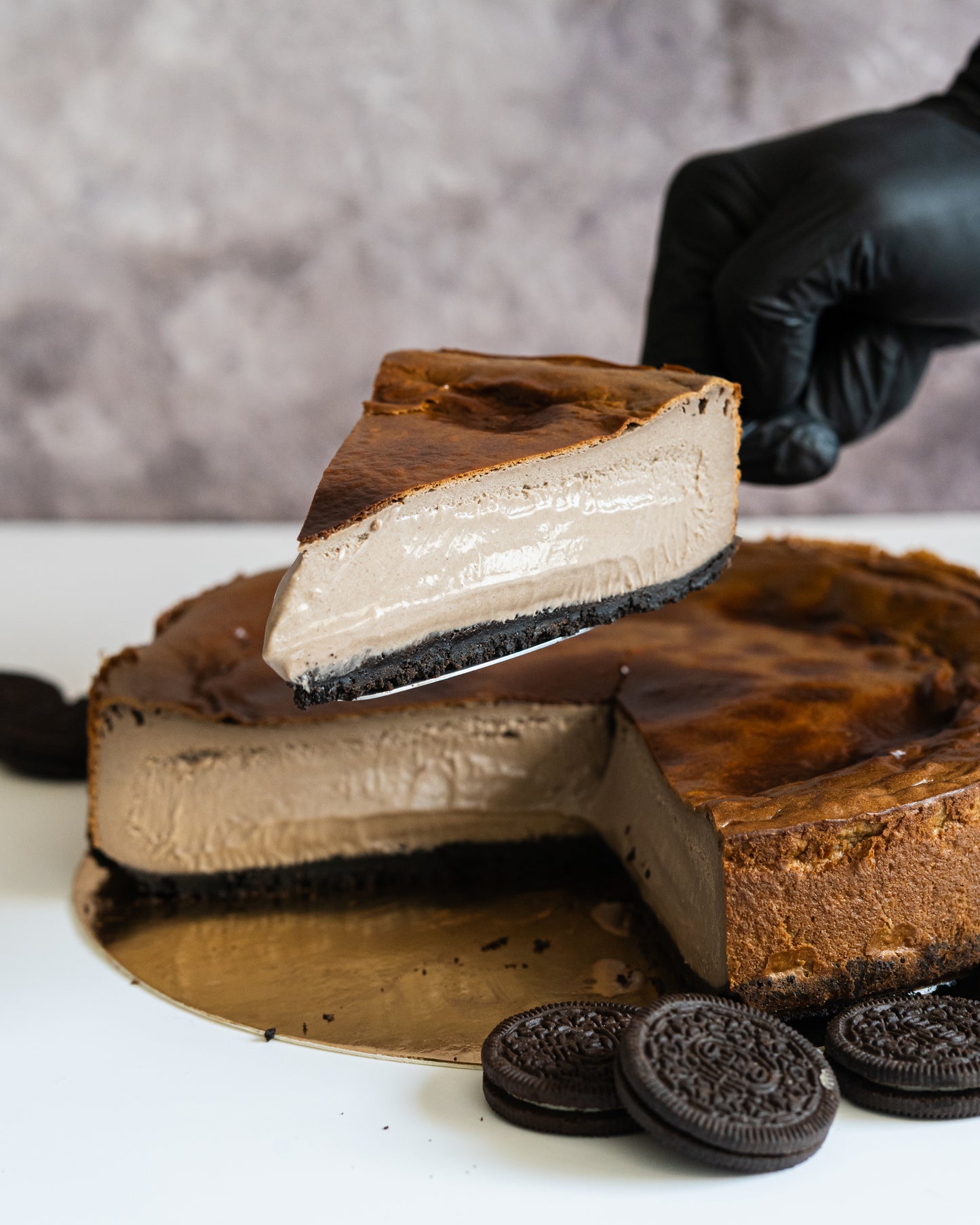 Porción en paleta sobre tarta grande de oreo